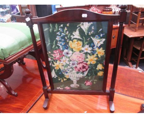 An early 20th century mahogany firescreen, having tapestry inset panel, pillar sides and shaped feet