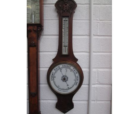 A late Victorian oak cased banjo barometer having carved crest and thermometer scale