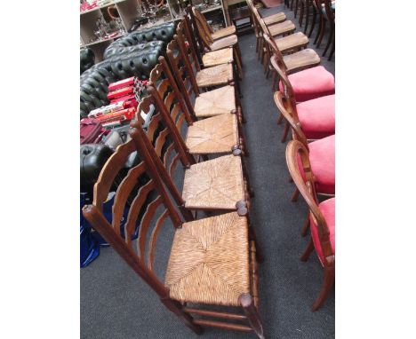 A set of eight (6+2) early 19th century elm vernacular country chairs having ladder backs and rush seats on turned legs