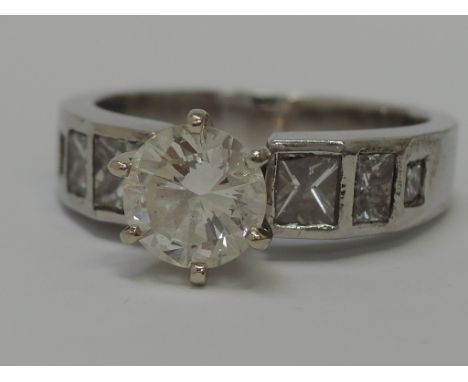 A ladies diamond solitaire dress ring approx .9ct having further princess cut diamonds mounted to the shoulders on a platinum