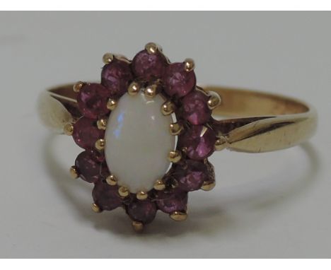 A ladies dress ring having an opal and ruby cluster on a 9ct gold loop