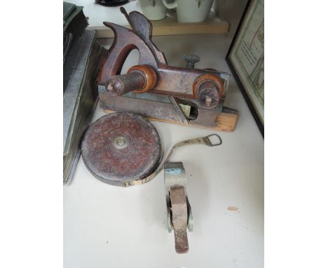 A vintage wooden spokeshave, a vintage brass bulls nose plane and a leather case tape measure