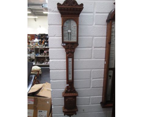 A 19th century Fitzroy type stick barometer in golden oak case by Husbands, Bristol, having carved decoration and thermometer