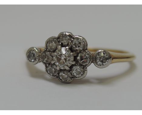 A ladies dress ring having small diamond cluster in rub over milligrain setting flanked by two further diamonds on a yellow m