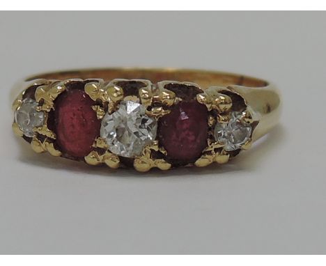 A Victorian ladies dress ring having two rubies interspersed by three diamonds in a claw set mount on a yellow metal loop tes