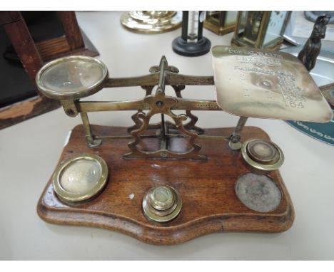 An early 20th century brass set of postal scales on mahogany base