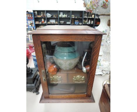 An Edwardian oak smoker's cabinet having Lovatts stoneware jar and pipes including meersham claw 