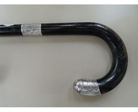 A vintage ebonized walking stick having HM silver mounts