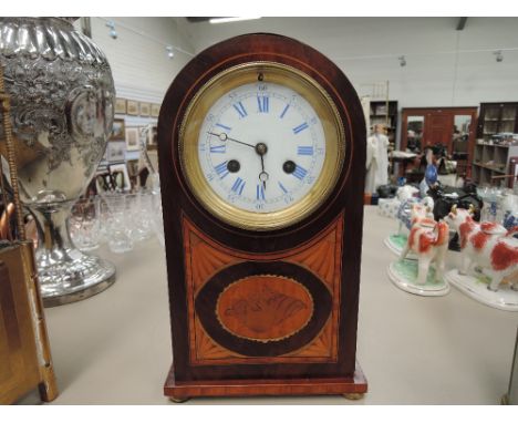 An Edwardian mahogany mantel clock of arch design having shell inlay decoration and blue and white dial