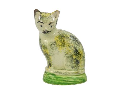 A 19th century Staffordshire pearlware cat - sponge decorated in black and yellow, 9cm high.