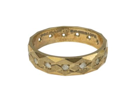 A 9ct gold eternity ring - arranged with white stones in a faceted band, size P, 3.4g.