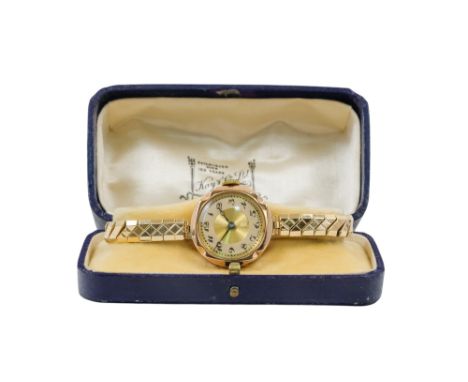 A 9ct gold cased ladies wristwatch by Buren - the two-tone dial set out with Arabic numerals, on an elasticated gilt metal st