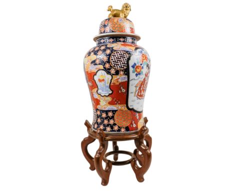 A large Imari vase - of baluster form, the cover with a gilt dog of fo, raised on a hardwood stand, vase 65cm high, overall h