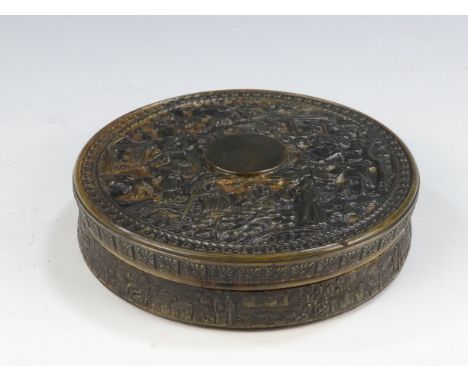 A 19th century Chinese tortoiseshell snuff box - circular and carved with figures in an exotic landscape, 9cm diameter.