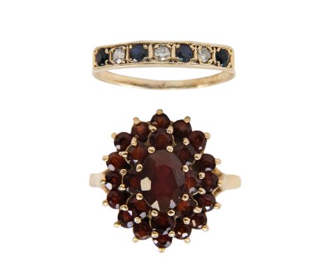 A 9ct gold garnet set ring - with a raised oval cluster setting, size P, 3.9g, together with a yellow metal diamond and sapph