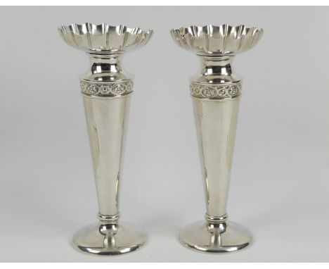 A pair of silver stem vases - London 1907, with fluted dish top above a band of patera, 21cm high.