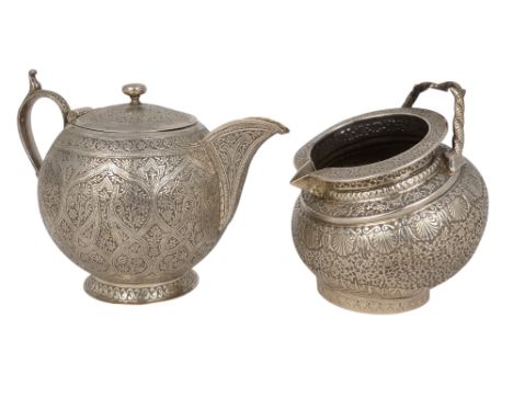 A late 19th century Anglo-Indian white metal bachelor bullet shaped teapot - engraved all over with foliage, together with an