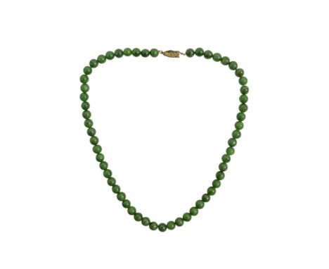 A dark green jade necklace - of uniform beads, length 46cm.