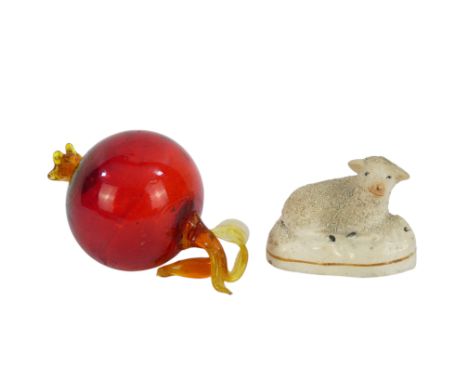 A 19th century Staffordshire model of a sheep - recumbent, 9cm wide, together with a glass decoration modelled as a pomegrana