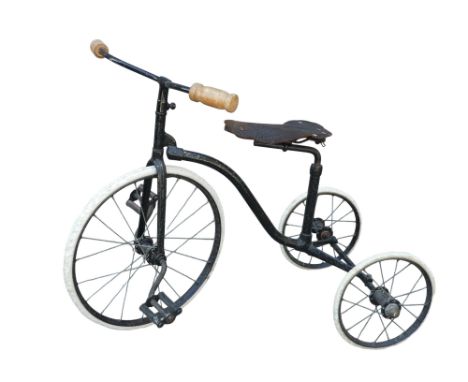 An early 20th century child's tricycle - black painted with hard white rubber tires and an associated Brooks saddle.