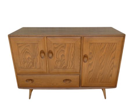 A 20th century elm sideboard by Ercol - model 467, with a pair of cupboard doors above a drawer and flanked by a cupboard to 