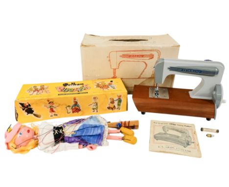 A Pelham puppet doll - modelled as a Dutch girl wearing a pink beret, boxed, together with a child's sewing machine, also box