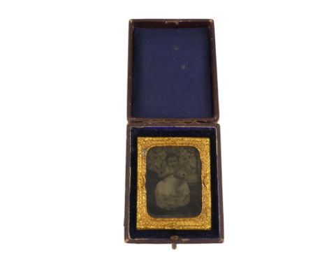 A late 19th century daguerreotype image of a young child - in a gilt metal frame and velvet lined box. 