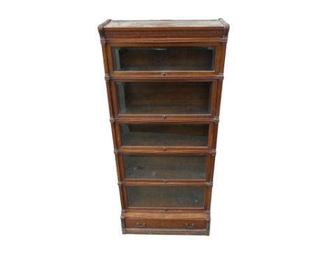 An early 20th century Globe Wernicke sectional oak bookcase - the moulded top incorporating a dentil cornice flanked by carve
