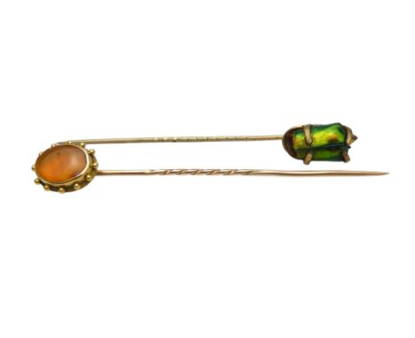 A gilt stock pin - with an oval amber setting, together with another stock pin. (2)
