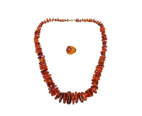 An irregular bead amber necklace - length 64cm, together with an amber ring.