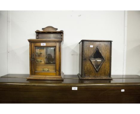 A SMALL SMOKERS CABINET WITH PIPE RACK TOP AND GLAZED DOOR, WITH THREE FITTED DRAWERS TO THE INTERIOR AND ANOTHER SMOKERS CAB