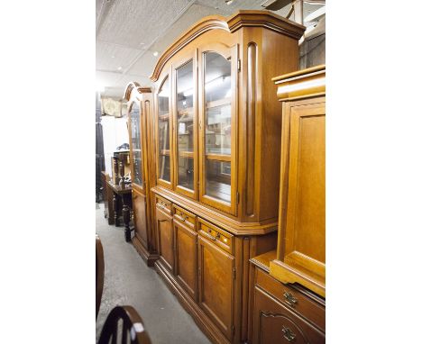 A MAHOGANY TALL SIDE CABINET WITH LOW ARCHED MOULDED CORNICE, THREE GLAZED DOORS ENCLOSING A MIRRORED INTERIOR WITH GLASS SHE