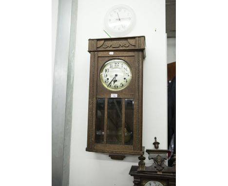 AN OAK CASED WELLINGTON WALL CLOCK 