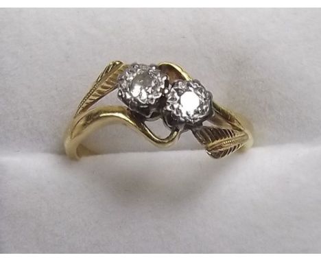 An 18 carat gold and platinum set diamond crossover ring - size N