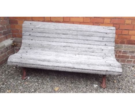 A Victorian wooden slatted garden bench on cast iron supports, 153cm wide