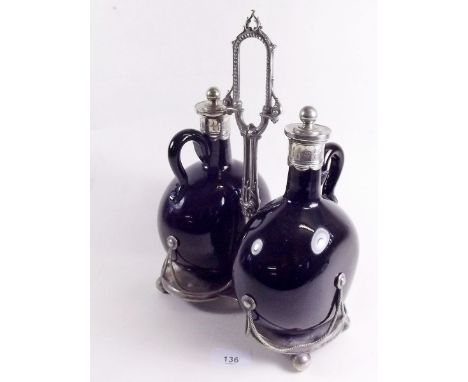 A pair of Victorian amethyst glass claret decanter with silver plated lids - one handle a/f, and a silver plated stand - a/f
