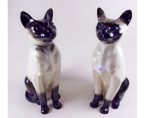 A pair of Siamese fireside cats, one by Doulton and one by Beswick - 35cm