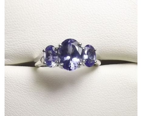 A 14K white gold tanzanite three stone ring, size N and a half