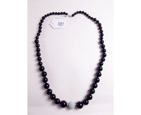 A 14k gold Chinese black stone necklace with single carved jade bead