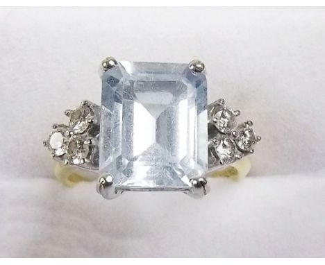 An 18 carat gold aquamarine ring on triple diamond set shoulders, size N