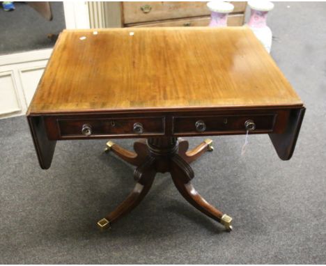 A late Regency mahogany sofa table, the rosewood crossbanded rectangular top and twin flaps with reeded edge, over two frieze