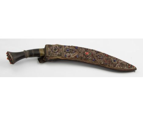 An early 20th century Nepalese khukri, the hilt and scabbard set with semi precious stones and coral cabochons and gilt scrol