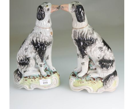 A pair of Victorian Staffordshire hunting dogs, each with black and white coat, gilt collar, separately moulded forelegs, on 