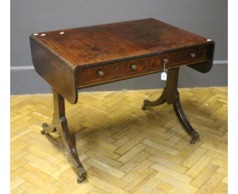 An early 19th century mahogany sofa table, the reeded edge top over two boxwood strung frieze drawers opposed by false with b