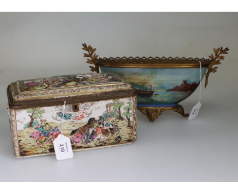 An early 20th century Capodimonte porcelain gilt metal mounted casket, the hinged lid and four sides decorated in shallow rel