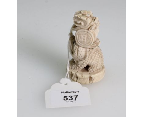 A 19th century Japanese ivory, carved as a chameleon with protruding tongue supporting a drum, 7.5cm