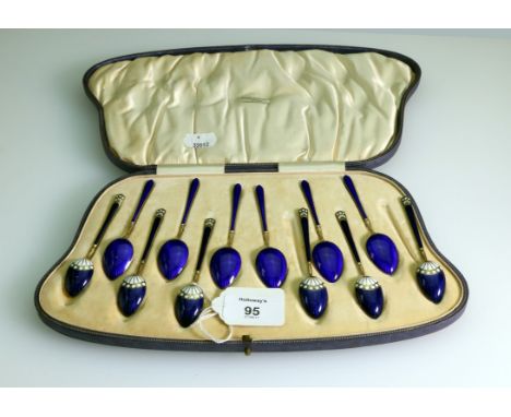 A cased set of twelve silver gilt and enamel teaspoons, of two designs, with import marks for London 1919