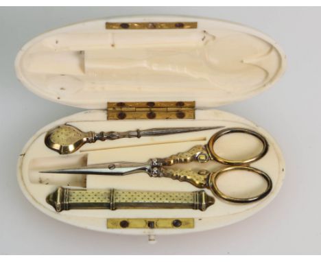 An early 20th century French ivory sewing box, of oval form containing scissors, needlecase and stitch pick, 6 x 11cm