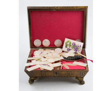 A Regency pearlware sarcophagus gaming box, wit gilt brass furniture, containing playing cards and a collection of finely eng