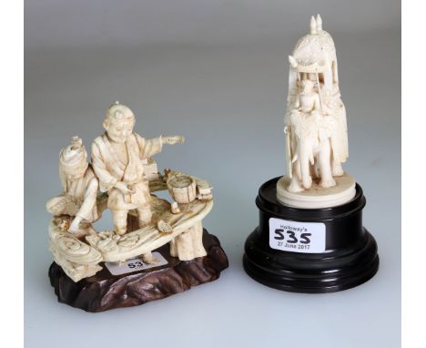 A Meiji Period carved ivory okimono, of two woodsmen beside various boxes and an orchid flower on a stump-like base, signed, 